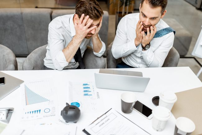 Exhausted employees working in the office preoccupazione per crisi di impresa